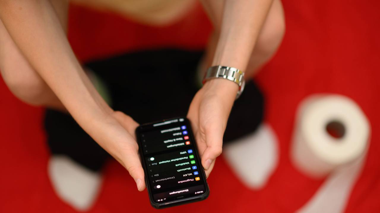 30.06.2022, Sachsen, Dresden: Eine Junge hält auf der Toilette sein Smartphone in den Händen. Immer mehr Deutsche nehmen ihr Smartphone mit auf die Toilette.