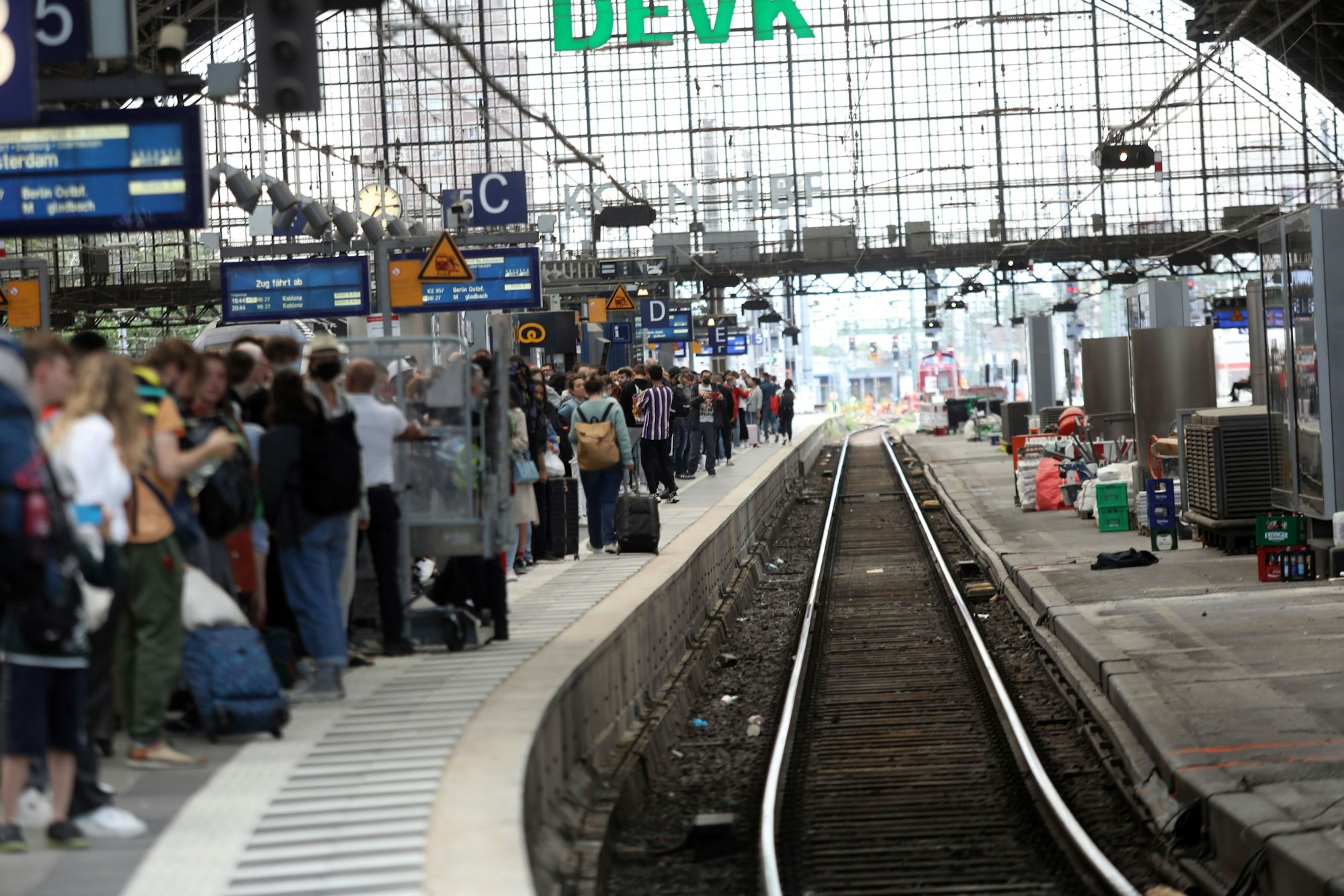 Menschen warten an Gleis 5 in Köln auf einen Zug.