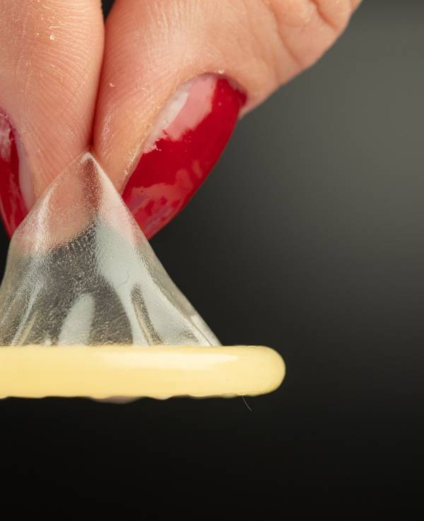 Eine Frau hält auf dem undatierten Symbolbild ein Kondom mit zwei Fingern. Forscher haben das Affenpocken-Virus in Sperma nachgewiesen.