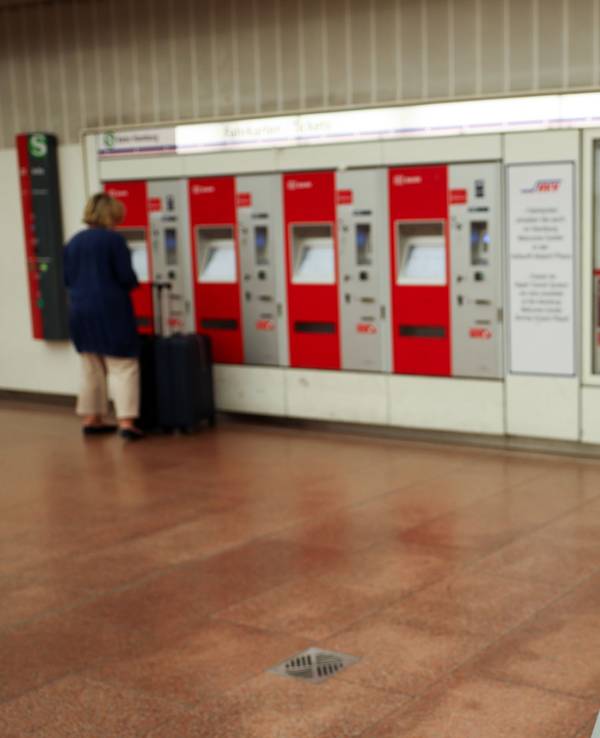 Ein Hinweisschild zum 9-Euro-Ticket ist vor einer Reihe Kartenautomaten der S-Bahn Hamburg in der Station am Flughafen zu sehen.