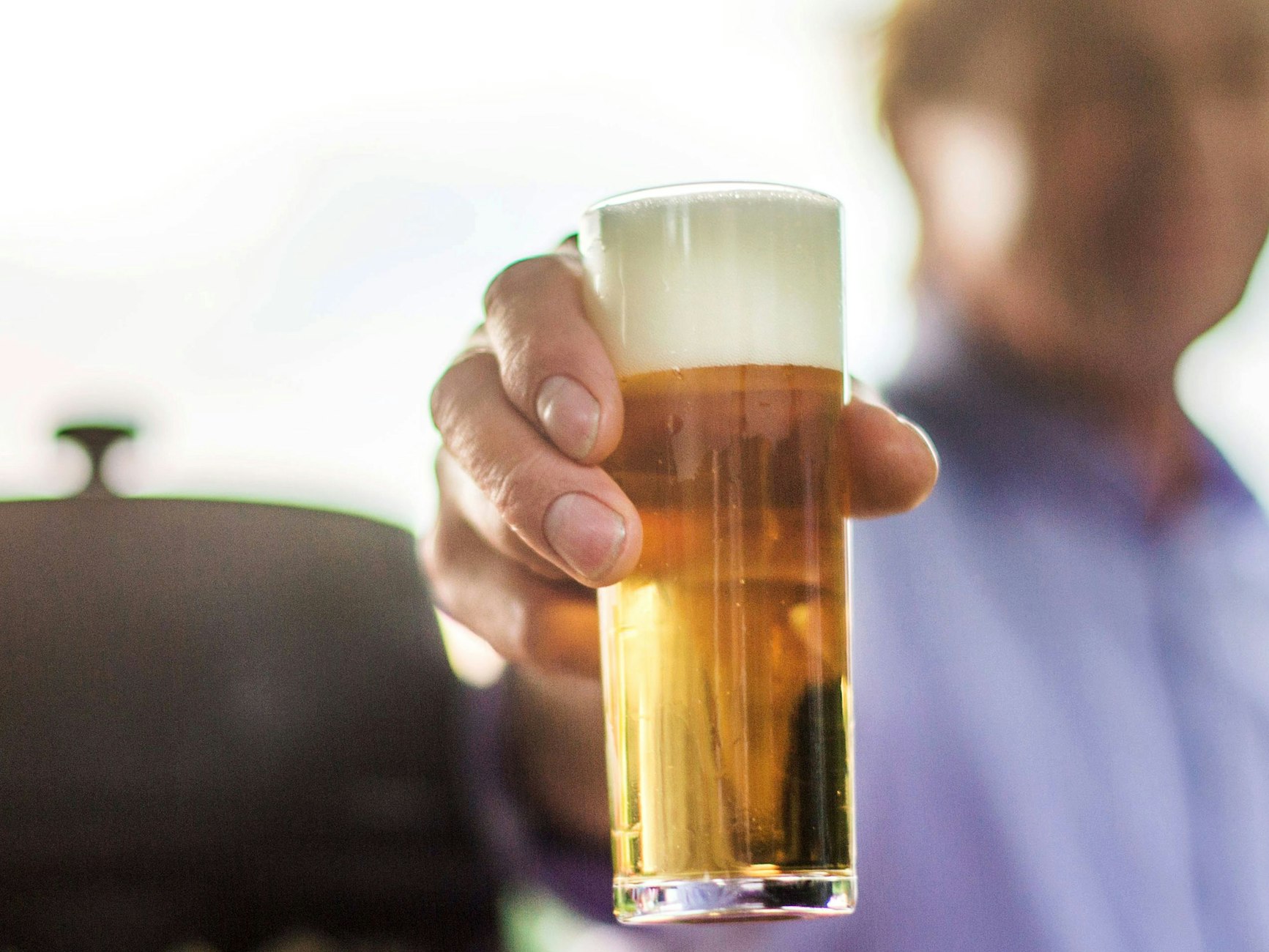 Ein frisch gezapftes Kölsch wird auf einer Party in die Kamera gehalten.