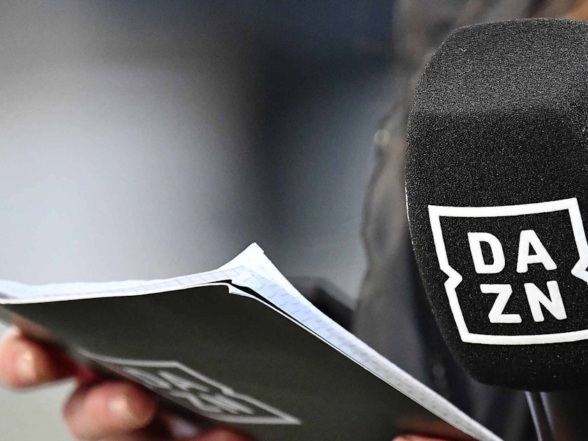 Ein Mikrofon und Moderations-Karten mit dem Logo des Streaming-Anbieters DAZN