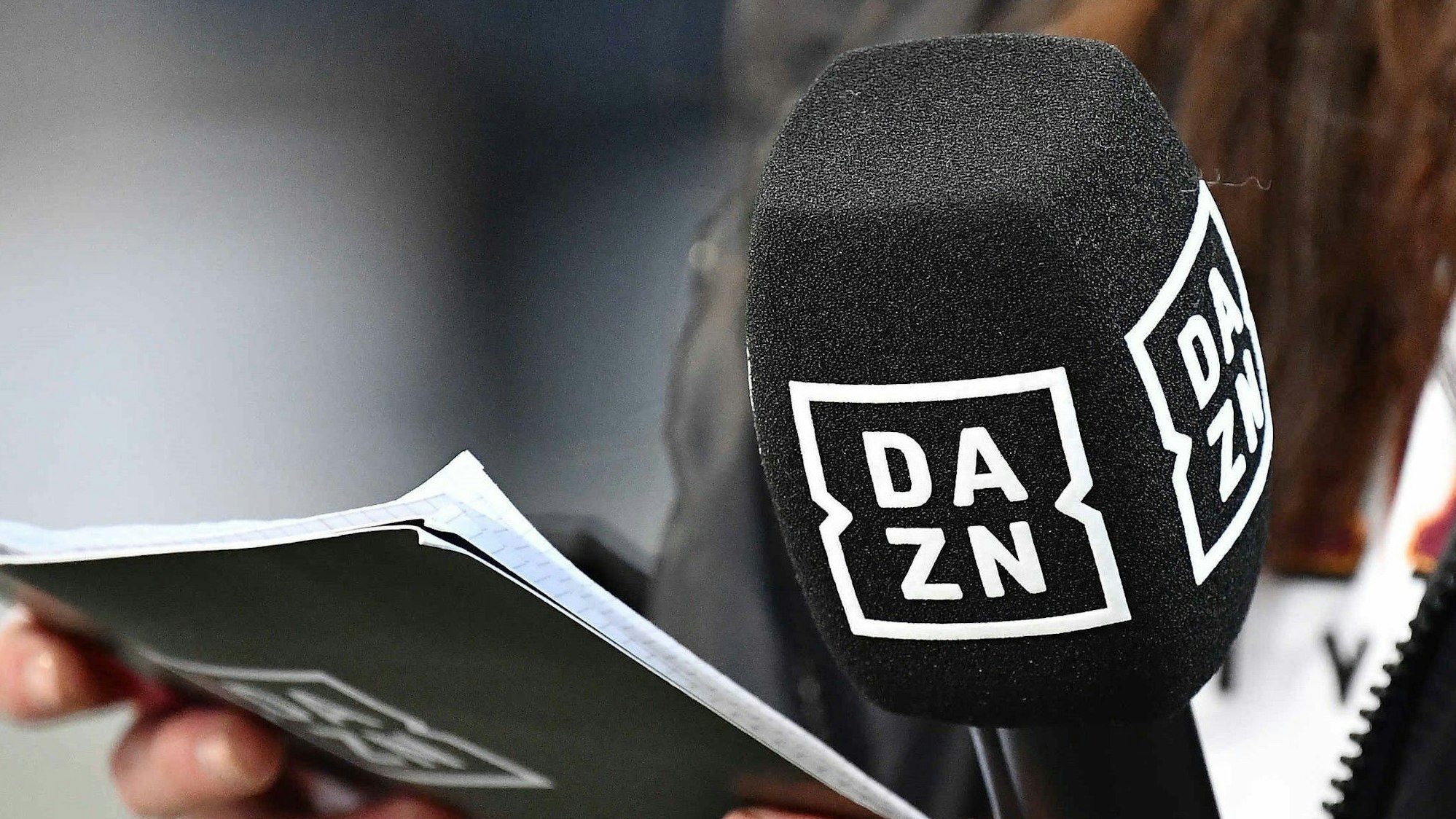 Ein Mikrofon und Moderations-Karten mit dem Logo des Streaming-Anbieters DAZN