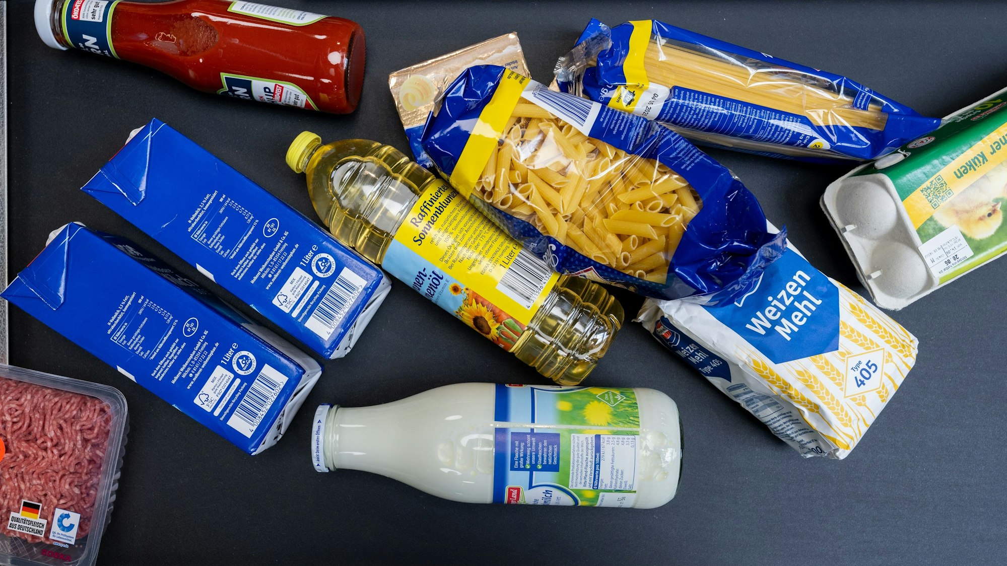 Lebensmittel, darunter Sonnenblumenöl und Getreideprodukte, liegen in einem Supermarkt in Leipzig an der Kasse auf dem Band. Der Einzelhandel plant weitere Preiserhöhungen, Bauernpräsident Joachim Rukwied sorgt sich vor allem um die Folgen bei einem Gasmangel.