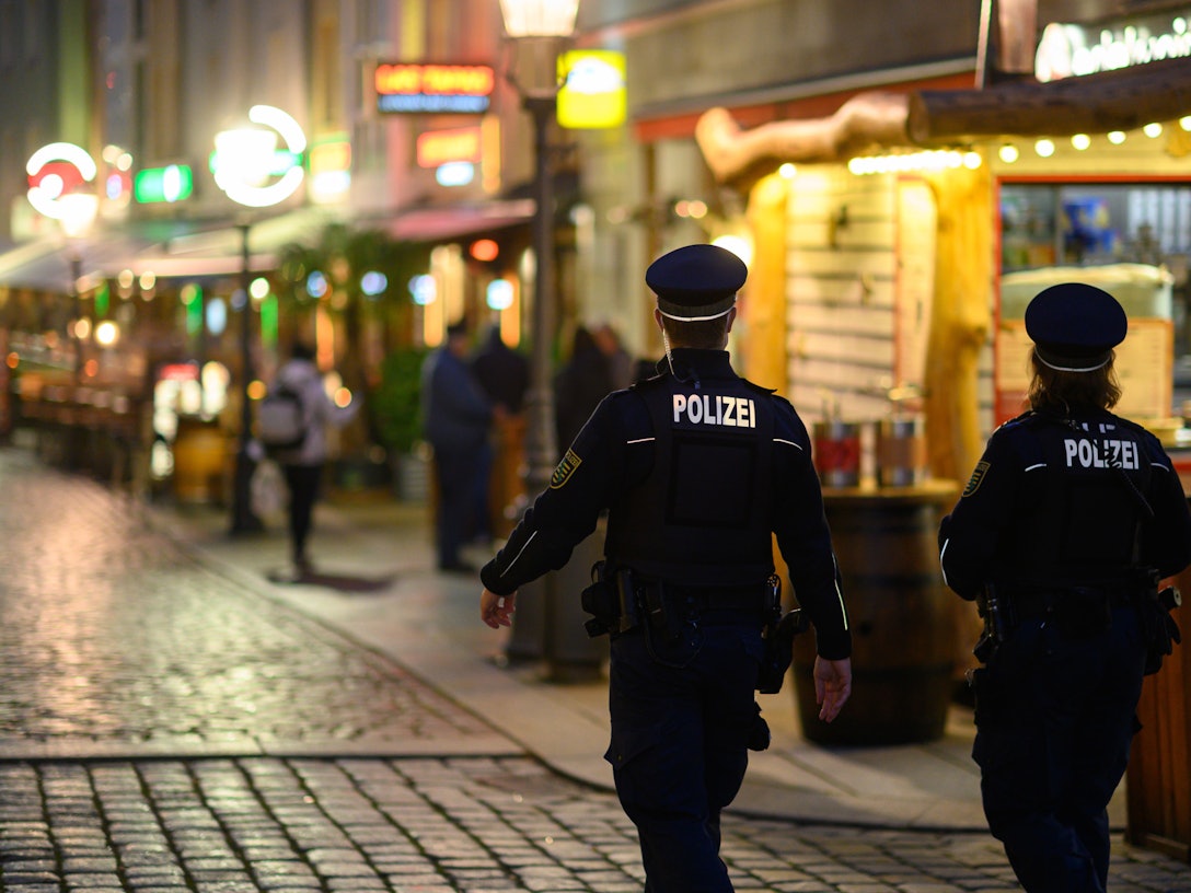 Deutschland in Zeiten des Corona-Lockdowns: Polizisten gehen am Abend in der Dresdner Altstadt an Restaurants entlang.