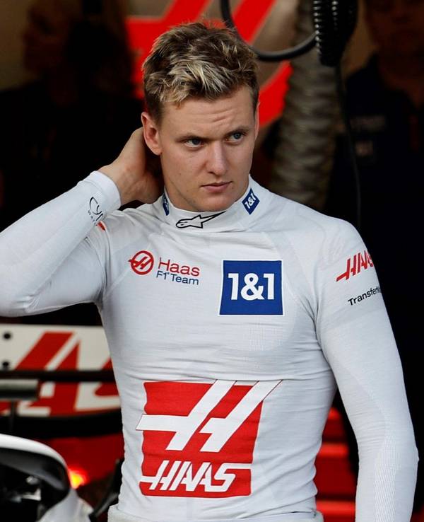 Mick Schumacher kratzt sich in der Box von Haas am Hinterkopf.