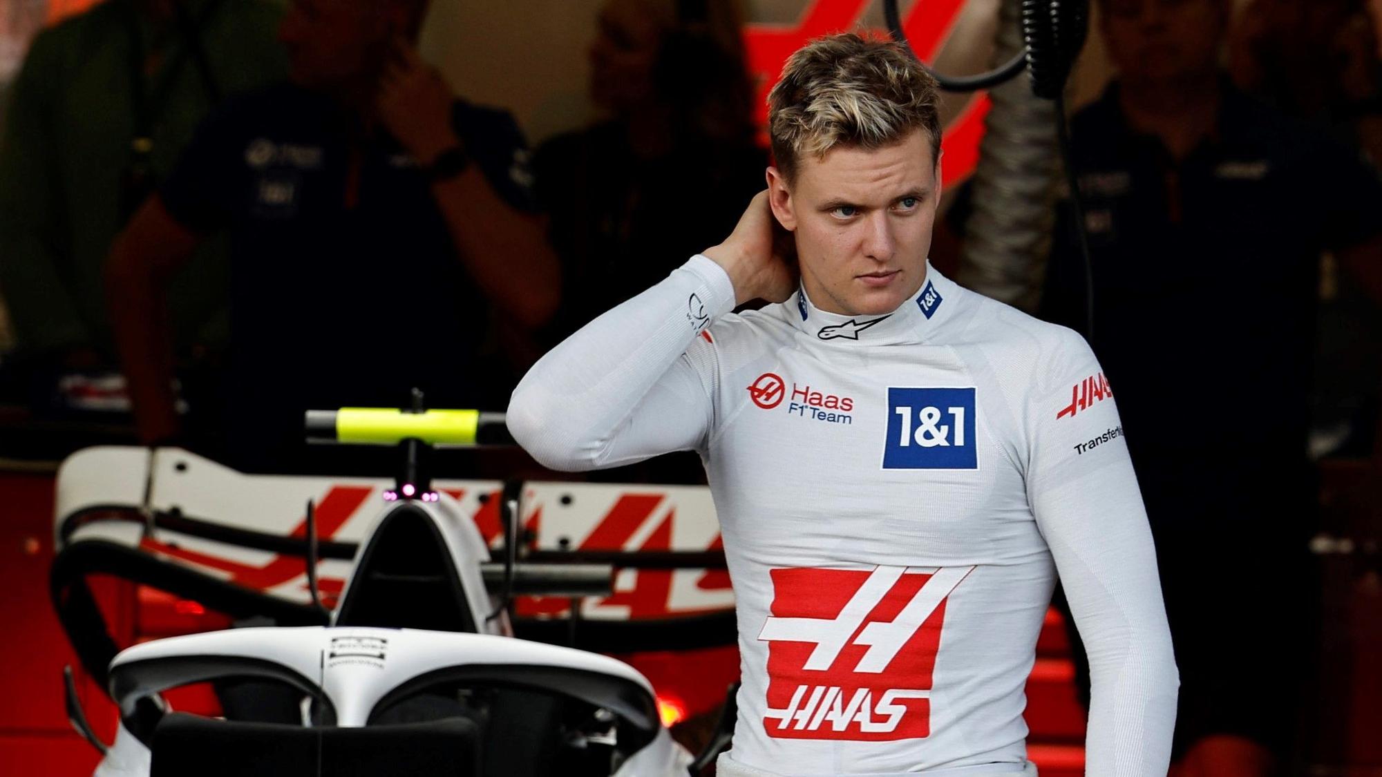 Mick Schumacher kratzt sich in der Box von Haas am Hinterkopf.