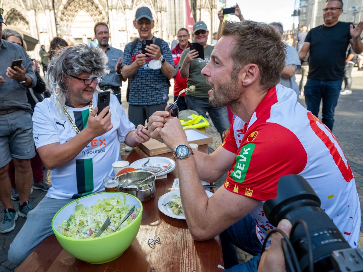 Dieter Könnes sitzt mit Markus Wipperfürth bei einer Spendenaktion auf der Kölner Domplatte.