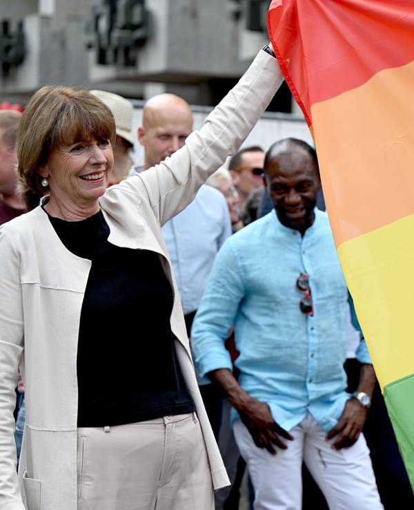 Henriette Reker, Kölner Oberbürgermeisterin, hilft beim Hissen einer Regenbogen-Flagge.