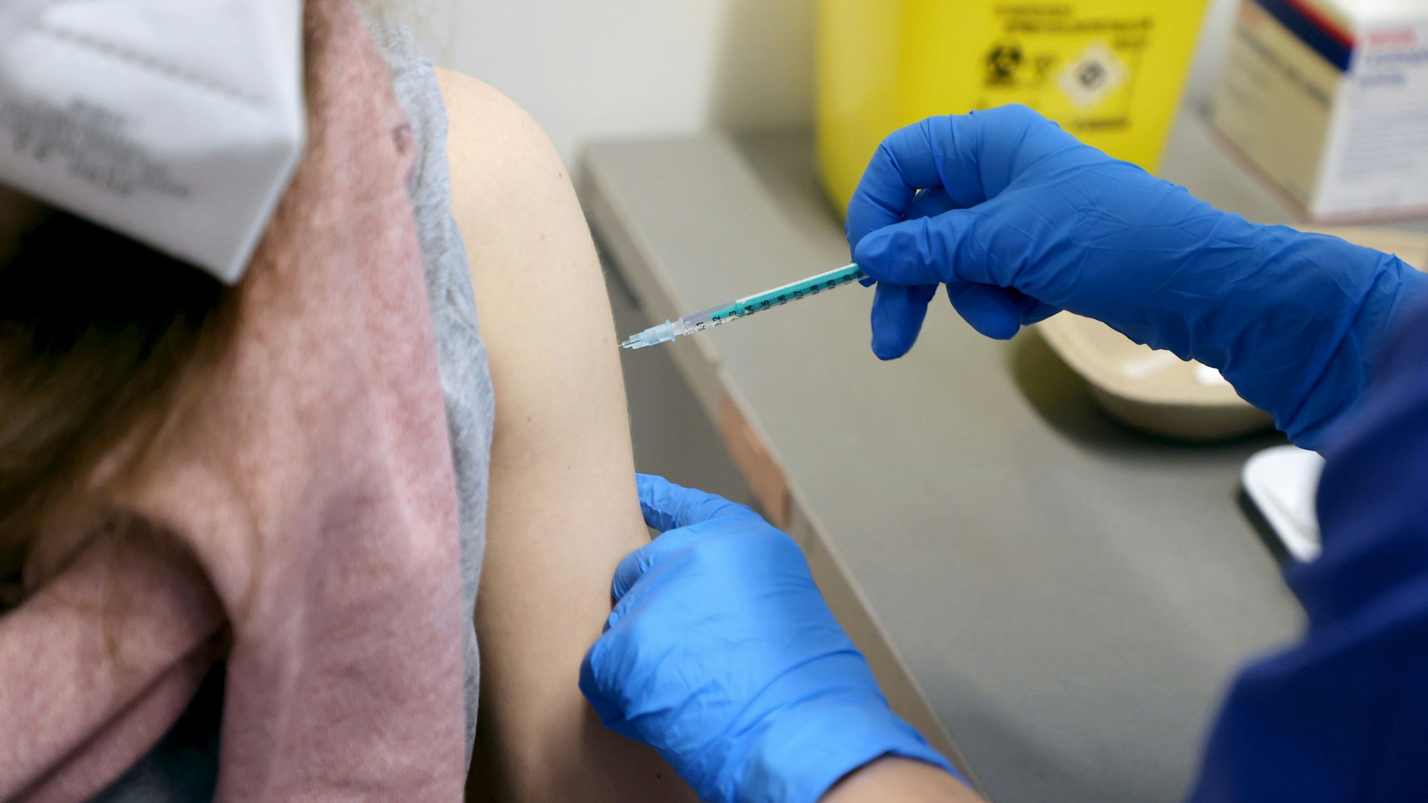 Eine Person bekommt eine Spritze in den Oberarm.