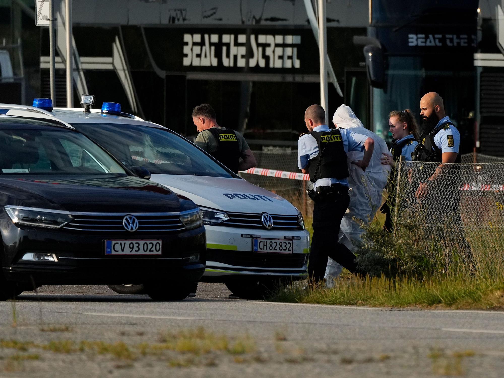 03.07.2022, Dänemark, Copenhagen: Einsatzkräfte der Polizei führen eine Person zu einem Polizeifahrzeug neben dem Einkaufszentrum Field's. Bei den Schüssen in einem Kopenhagener Einkaufszentrum sind mehrere Menschen getötet worden.