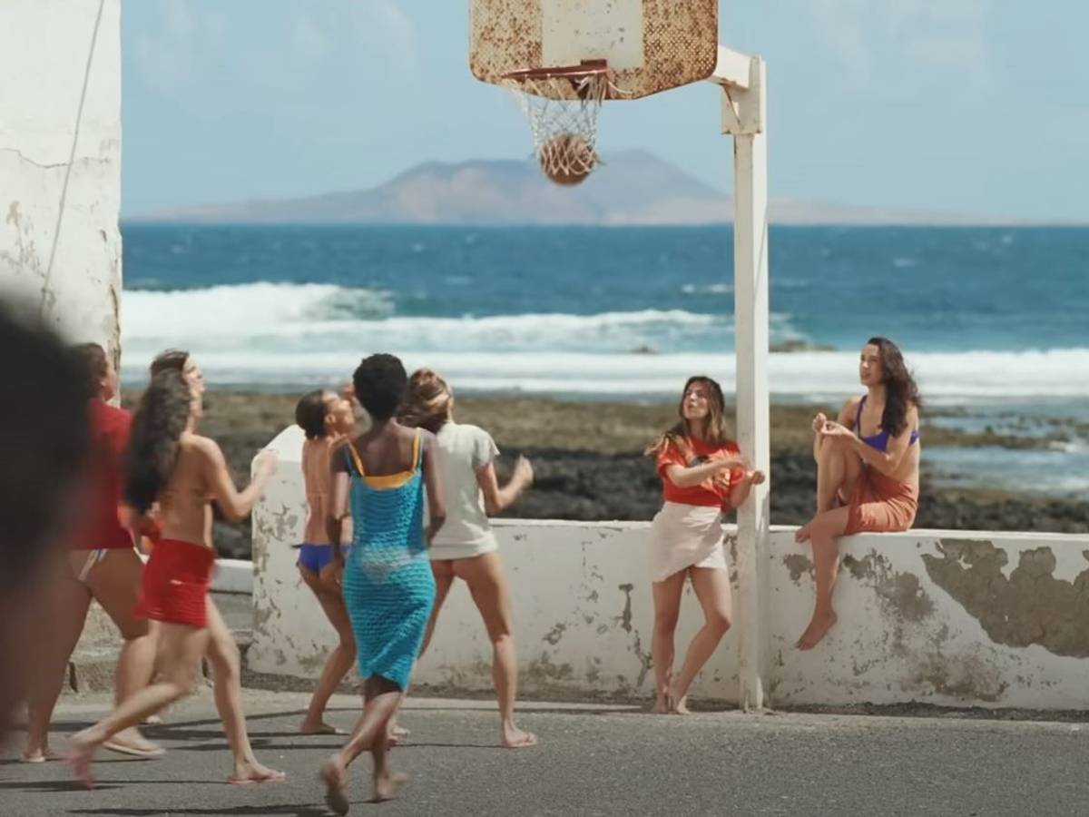 Screenshot aus dem Musikvideo „Provenza“ der kolumbianischen Sängerin Karol G. Mehrere Frauen spielen an der Promenade vor dem Meer Basketball.