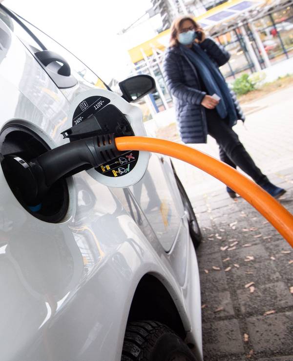 Auto steht an einer elektrischen Ladesäule und wird aufgeladen.