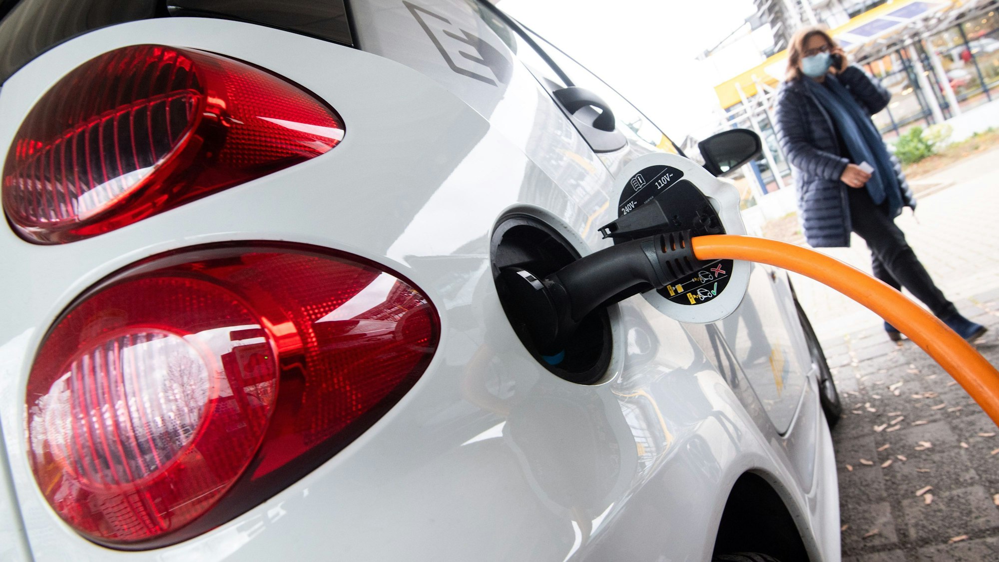 Auto steht an einer elektrischen Ladesäule und wird aufgeladen.