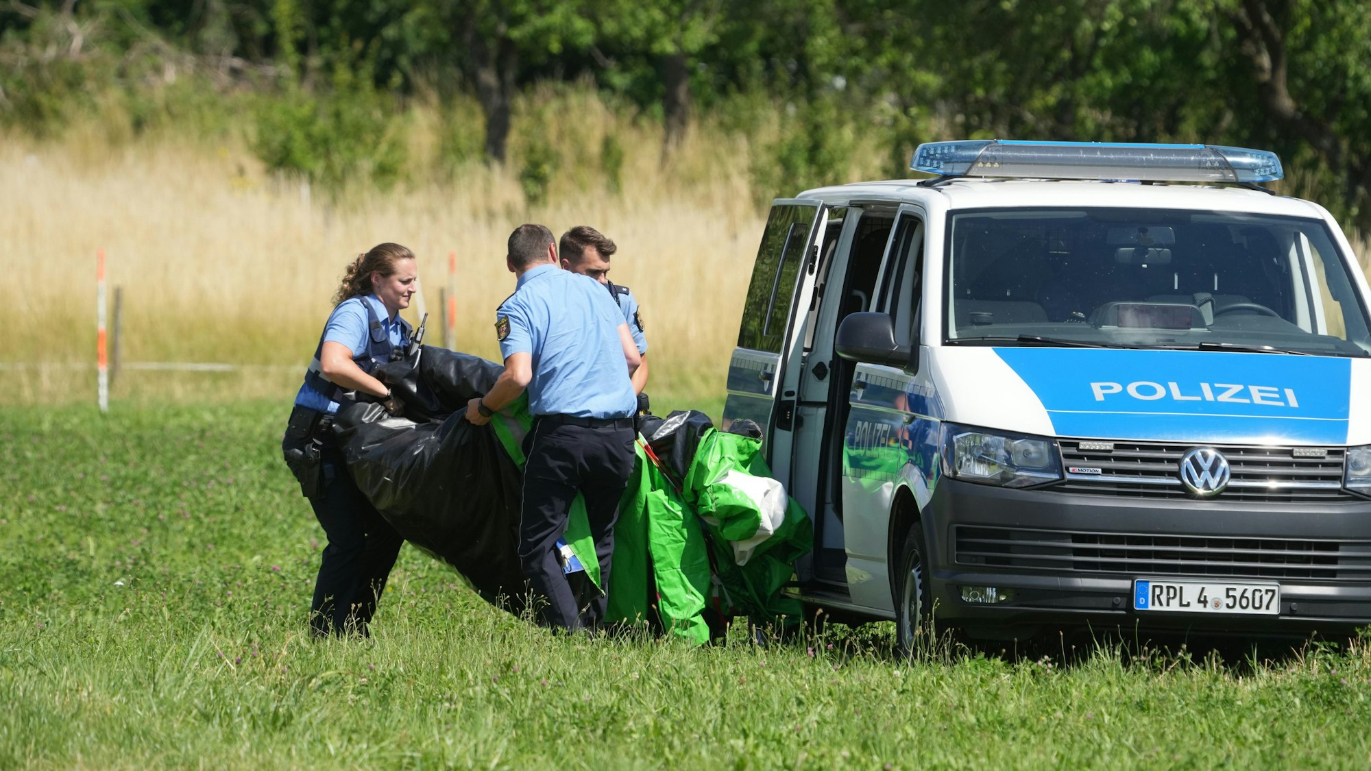 Rheinland-Pfalz, Gondershausen: Polizeibeamte transportieren die Hülle einer Hüpfburg ab.