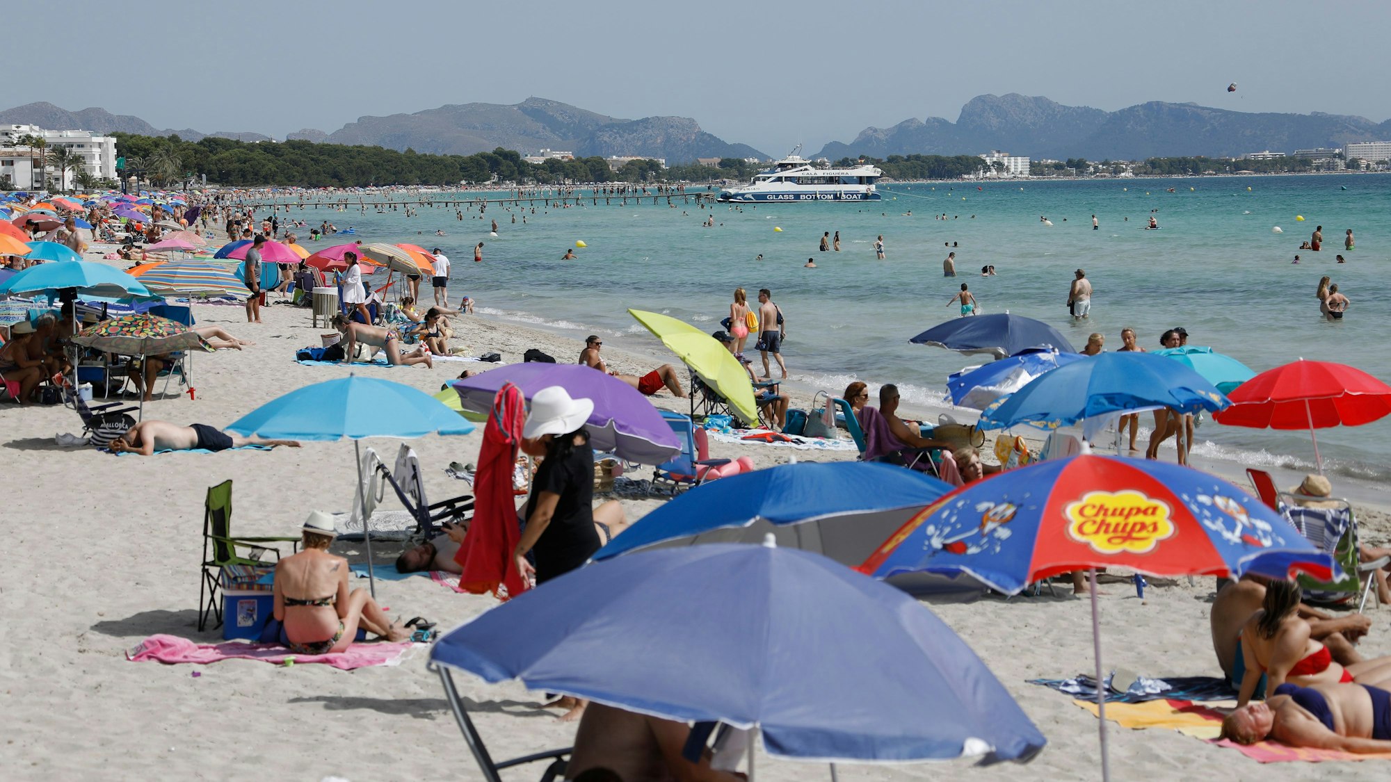 Urlaub in der spanischen Sonne ist der Traum vieler Jugendlicher. Doch in den Jugendcamps gibt es weiter viele kranke Kinder. Das undatierte Symbolbild zeigt Urlauber und Urlauberinnen am Strand von Playa de Muro im Norden von Mallorca.