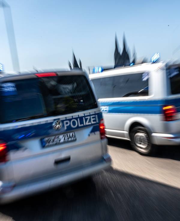 Polizeifahrzeuge fahren mit Blaulicht über die Deutzer Brücke in Köln.