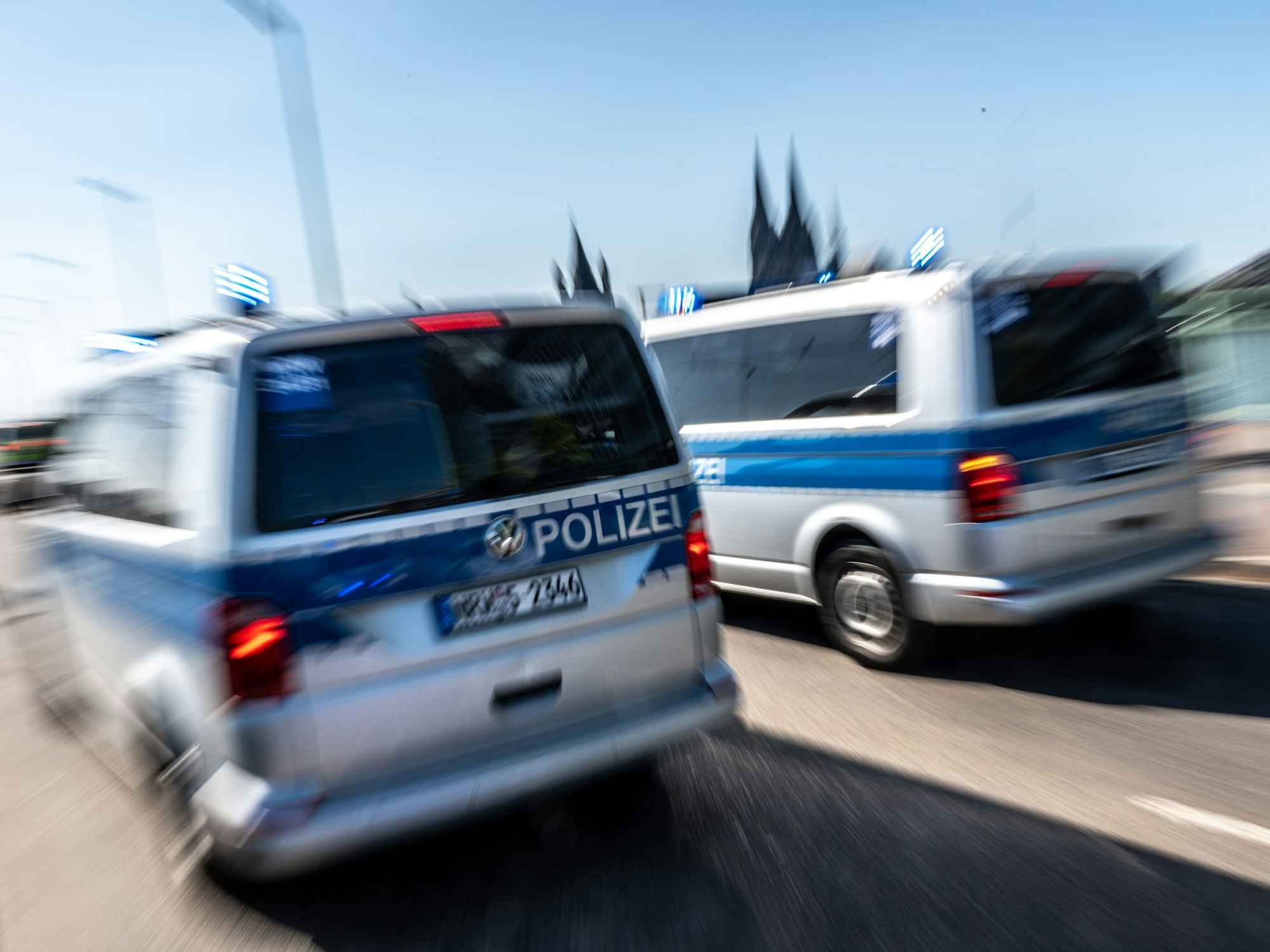 Polizeifahrzeuge sind mit Blaulicht auf der Deutzer Brücke in Köln unterwegs.