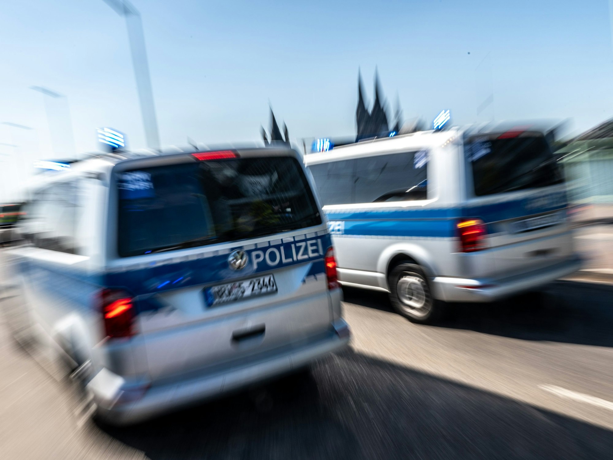 Polizeifahrzeuge sind mit Blaulicht auf der Deutzer Brücke im Einsatz.