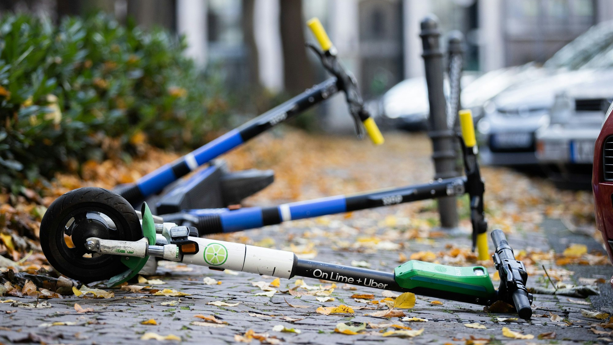 E-Scooter liegen auf einem Gehweg und versperren den Weg.