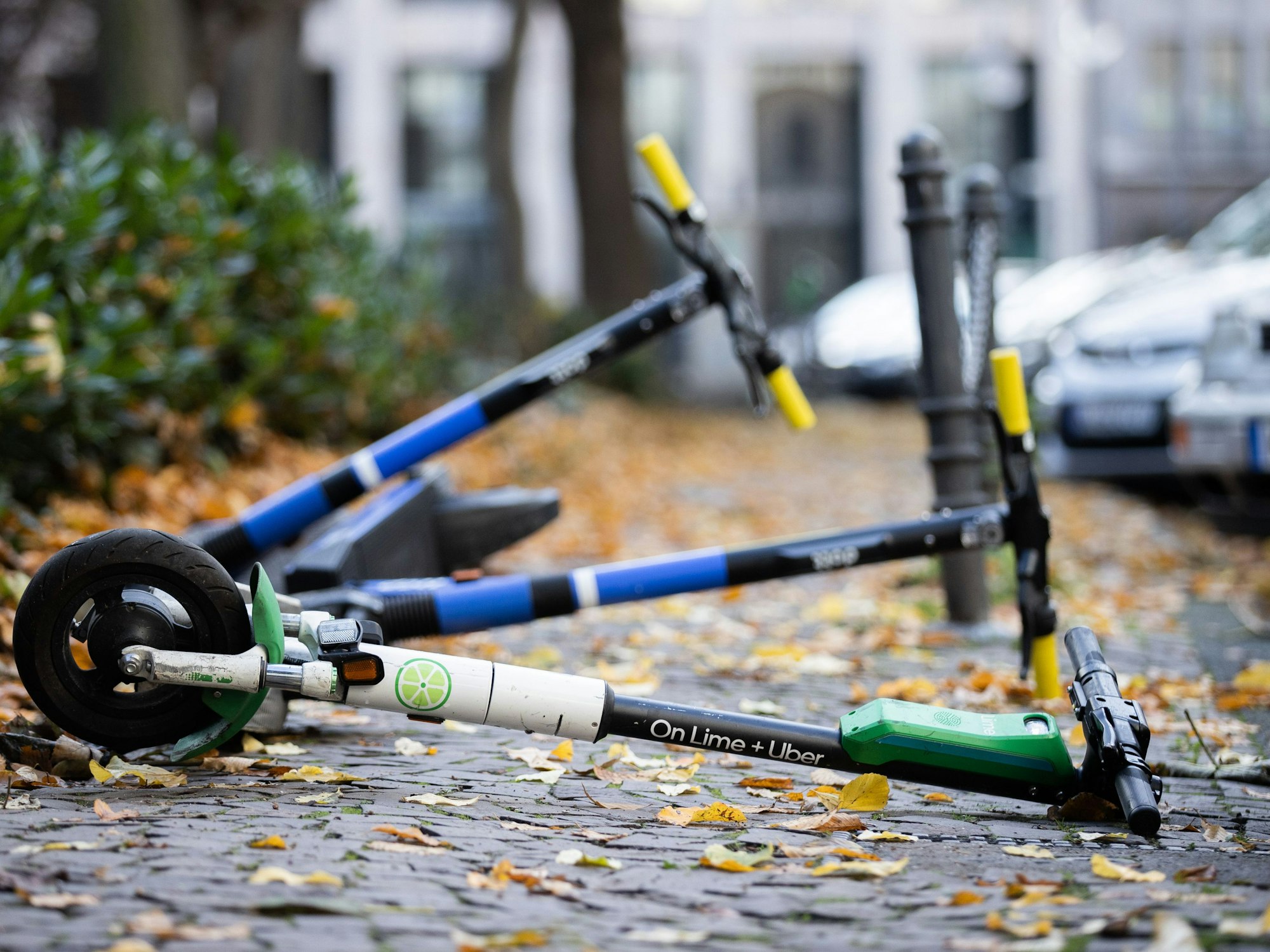 E-Scooter liegen auf einem Gehweg und versperren den Weg.