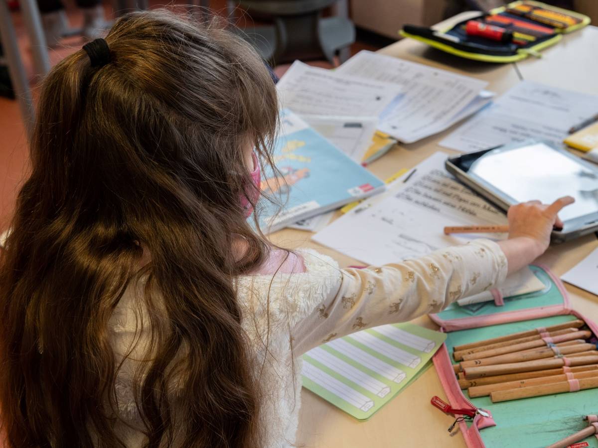Eine Grundschülerin arbeitet im Klassenraum an ihren Schulaufgaben.