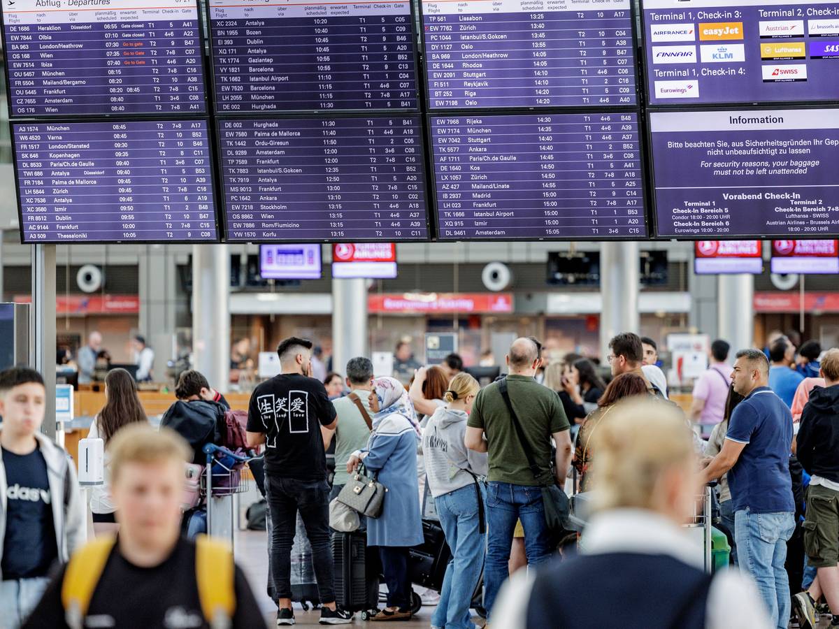 Fluggäste warten am 3. Juli 2022 im Helmut Schmidt Flughafen in Hamburg vor den Check-In Schaltern auf die Abfertigung. Zu Beginn der Sommerferien herrscht im Norden großer Andrang am Flughafen.