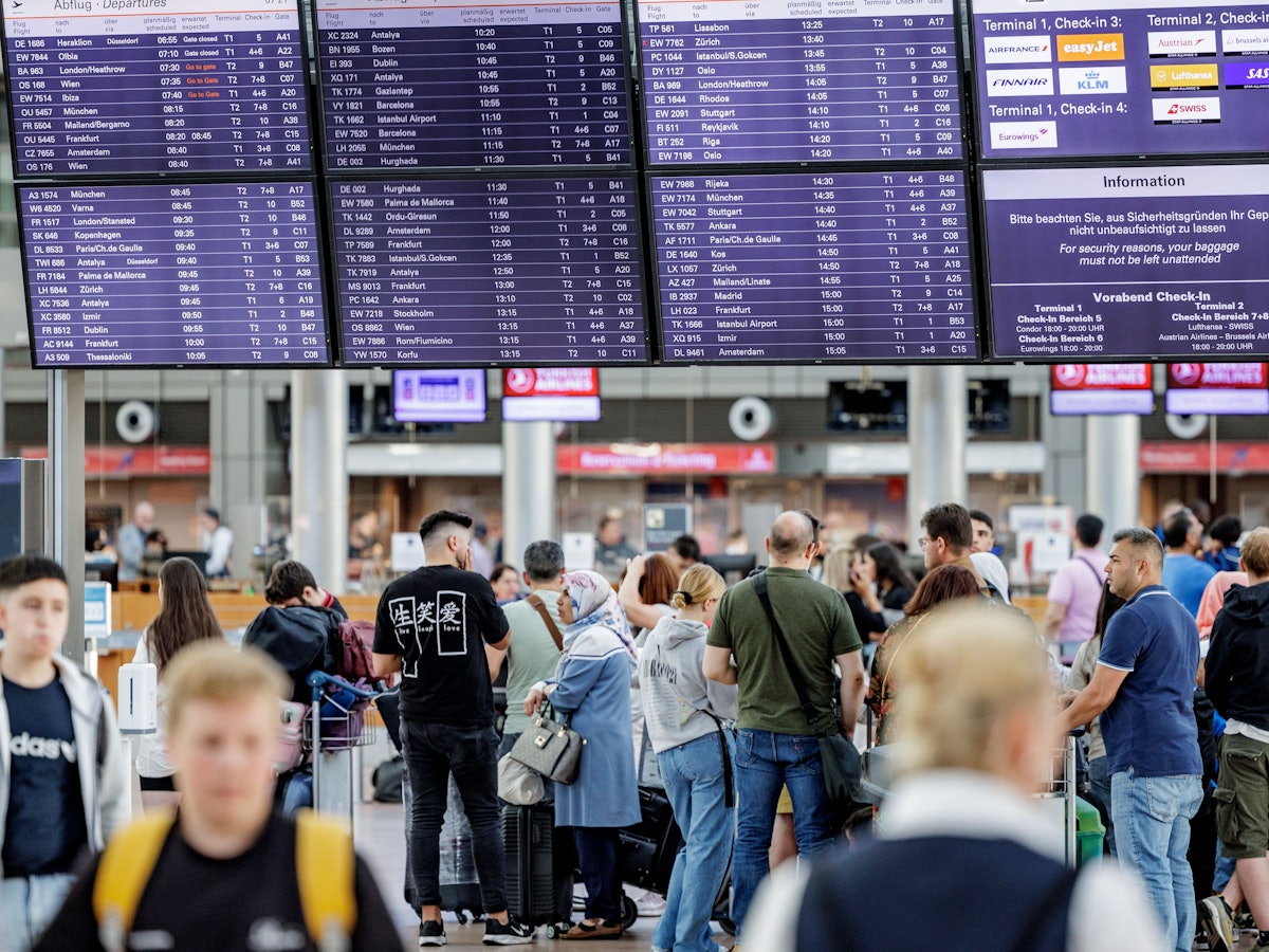 Fluggäste warten am 3. Juli 2022 im Helmut Schmidt Flughafen in Hamburg vor den Check-In Schaltern auf die Abfertigung. Zu Beginn der Sommerferien herrscht im Norden großer Andrang am Flughafen.