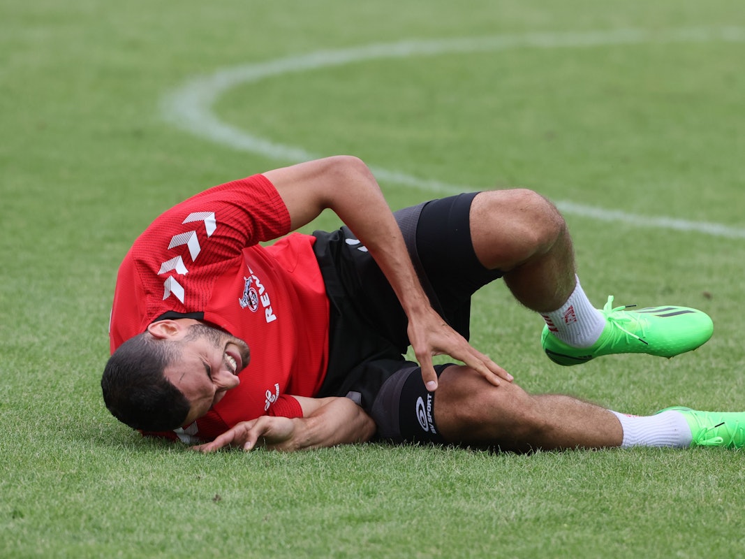 Ellyes Skhiri liegt im Trainingslager des 1. FC Köln in Donaueschingen auf dem Rasen.