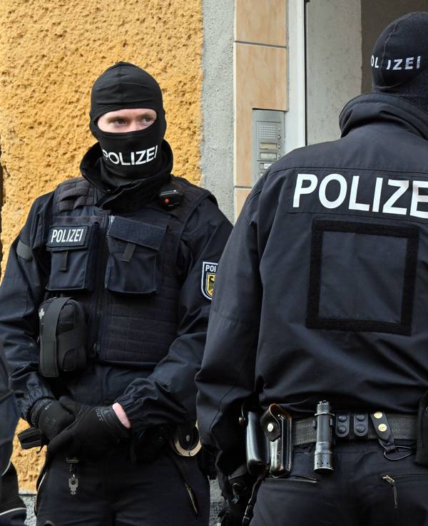 Bundespolizisten stehen vor einem Hauseingang.