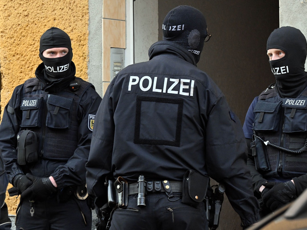 Bundespolizisten stehen vor einem Hauseingang.