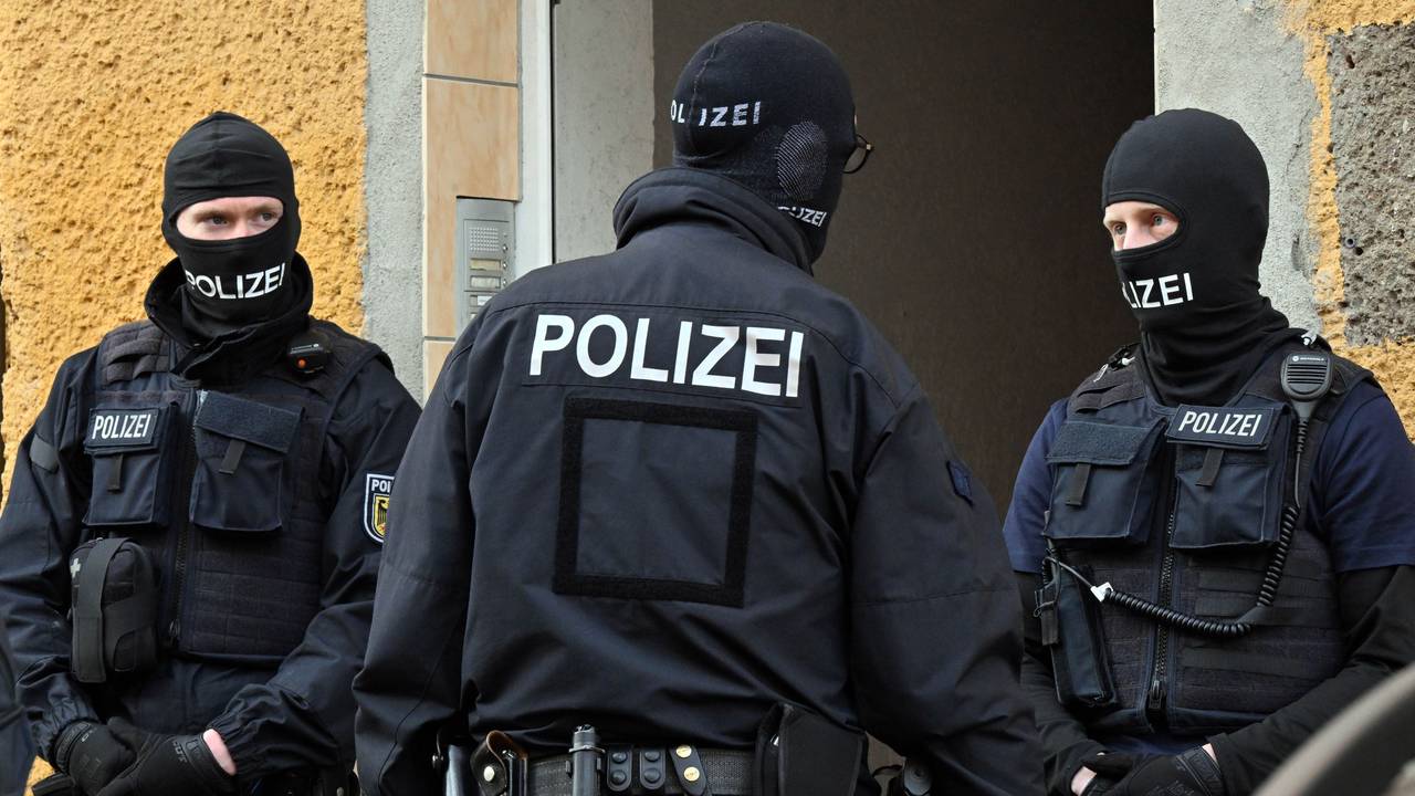 Bundespolizisten stehen vor einem Hauseingang.