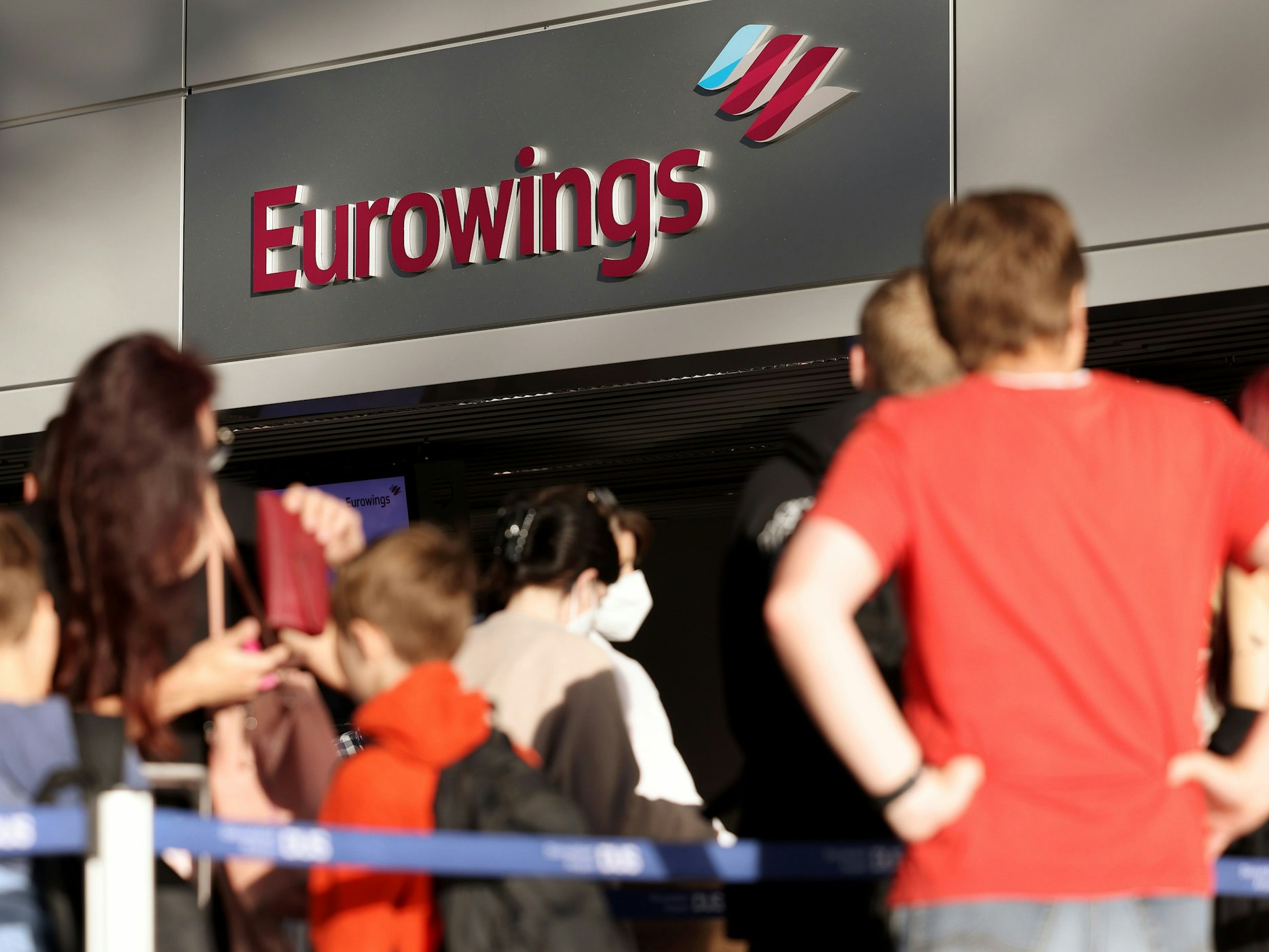 Passagiere stehen Schlange vor dem Check-in-Schalter von Eurowings im Flughafen DĂŒsseldorf.