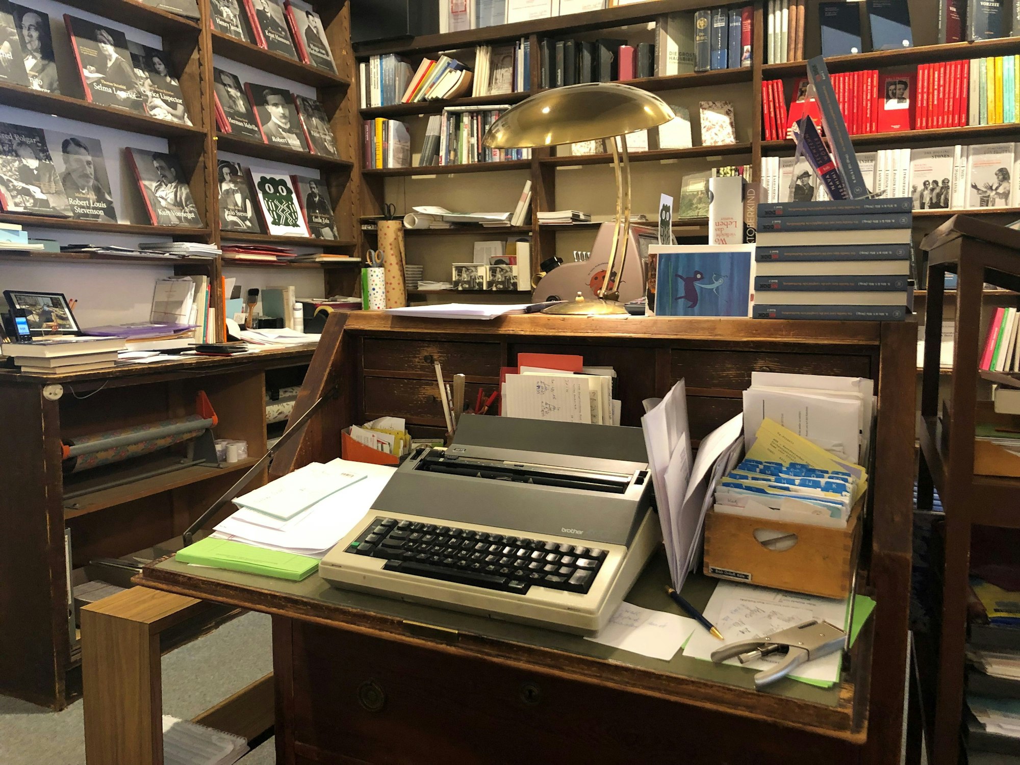 Eine elektrische Schreibmaschine steht auf einem alten Holzsekretär.