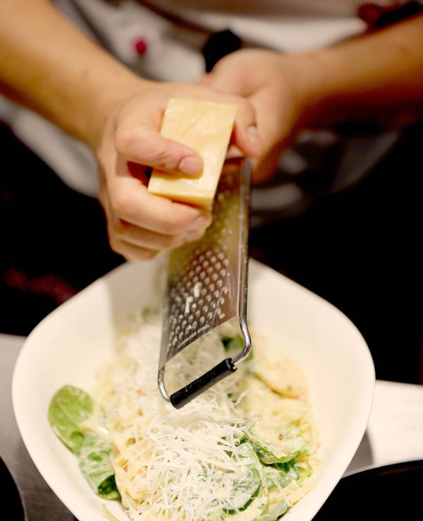 Das Symbolfoto von Parmesan, der über Pasta gerieben wird, wurde 2019 in Köln aufgenommen.