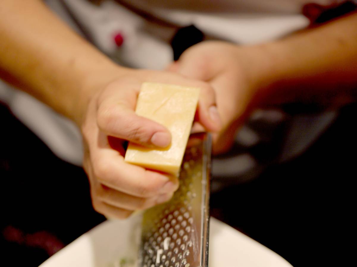 Das Symbolfoto von Parmesan, der über Pasta gerieben wird, wurde 2019 in Köln aufgenommen.