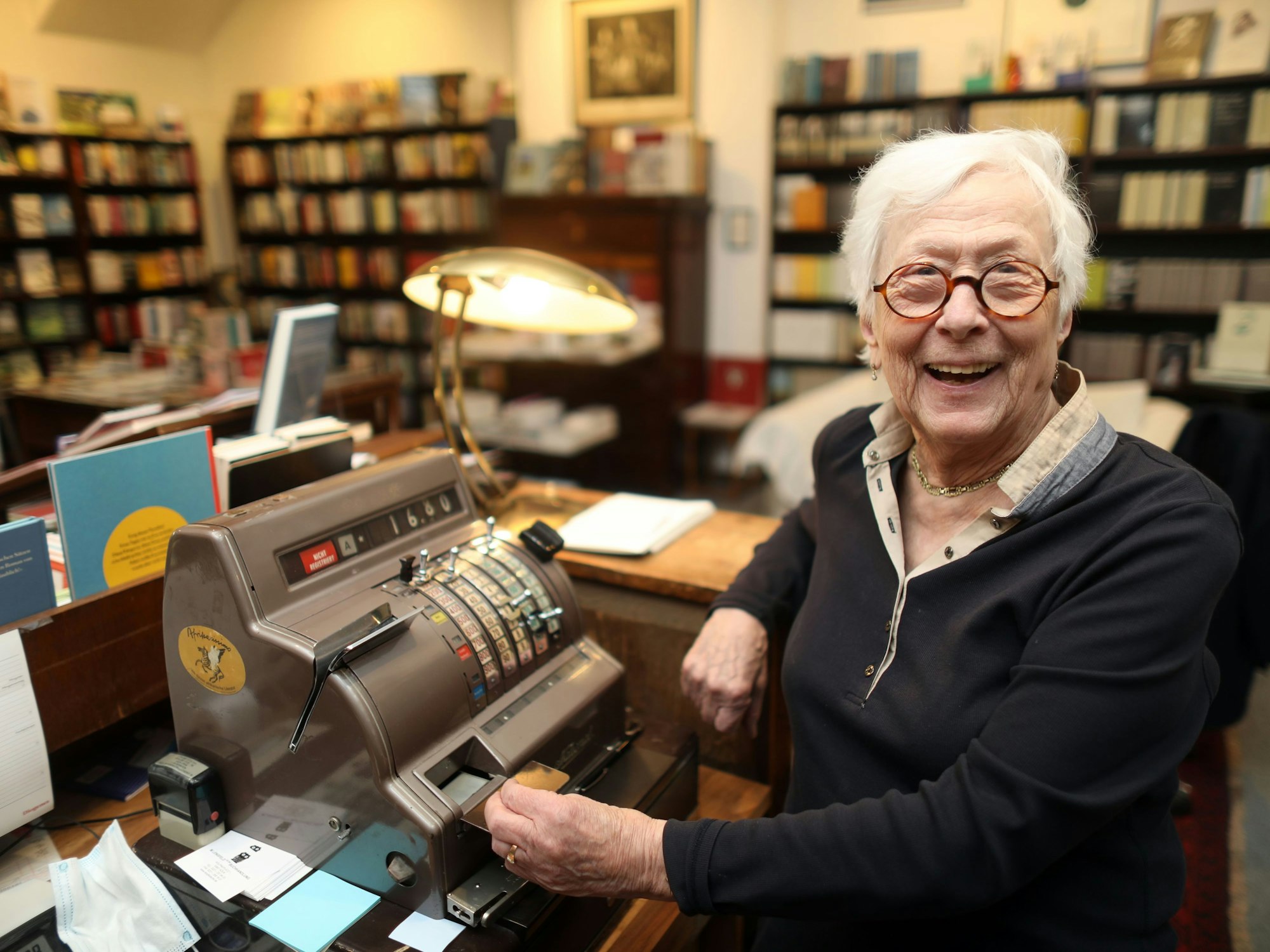 Hildegund Laaf sitzt an der alten Kasse in ihrer Buchhandlung.