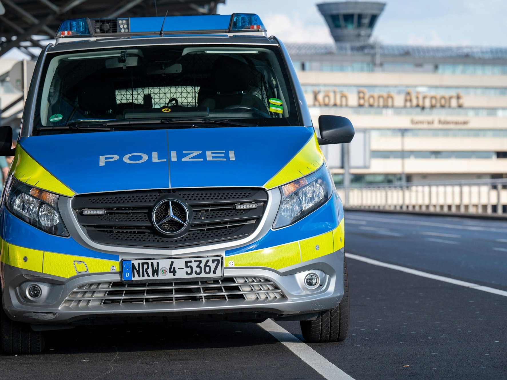 Ein Polizeifahrzeug steht vor einem Gebäude mit dem Schriftzug „Köln Bonn Airport“.