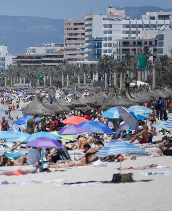 Touristen und Touristinnen genießen im Juli 2021 die Sonne am Strand von Arenal.
