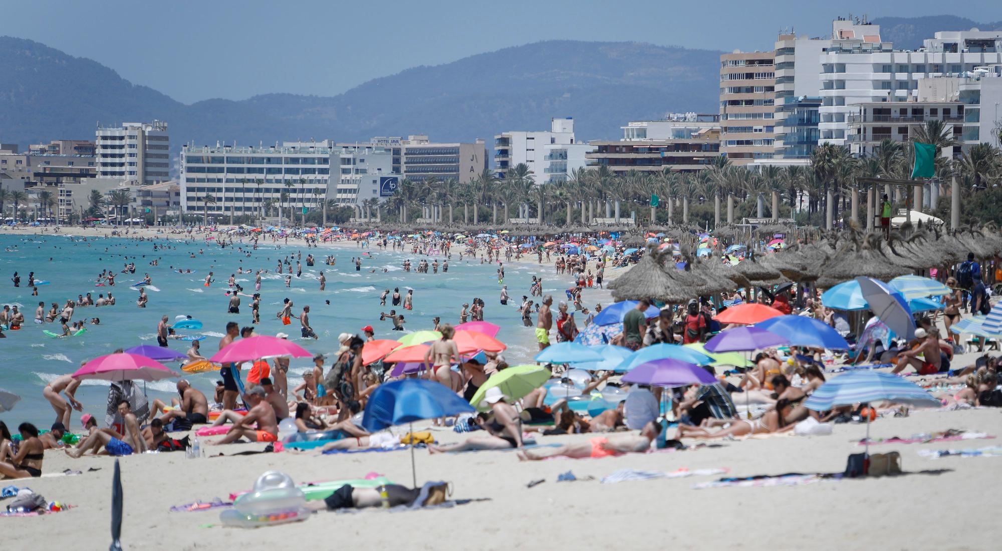 Touristen und Touristinnen genießen im Juli 2021 die Sonne am Strand von Arenal.