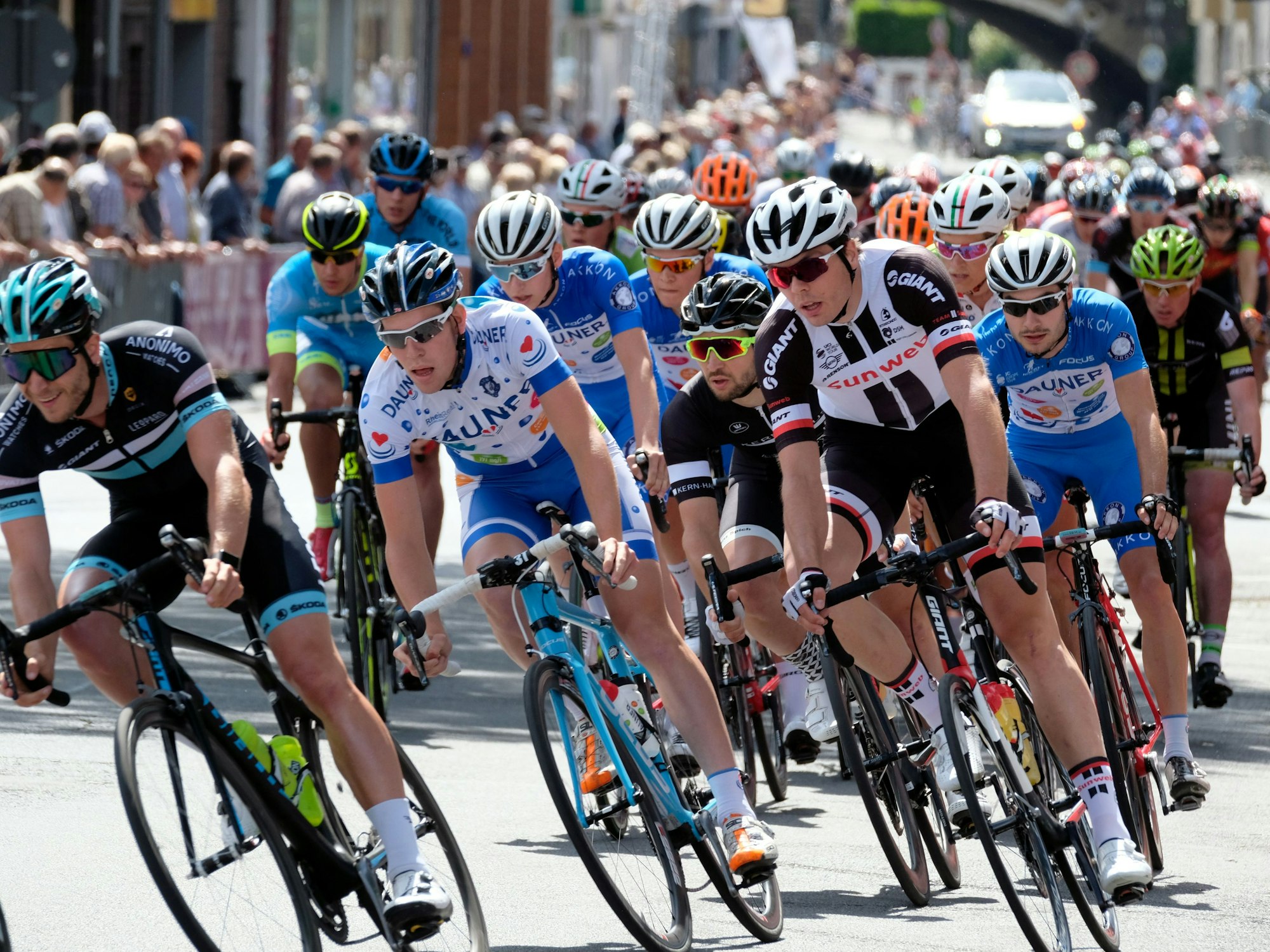 Das Fahrerfeld beim Hauptrennen der Cologne Classics biegt in eine Kurve.