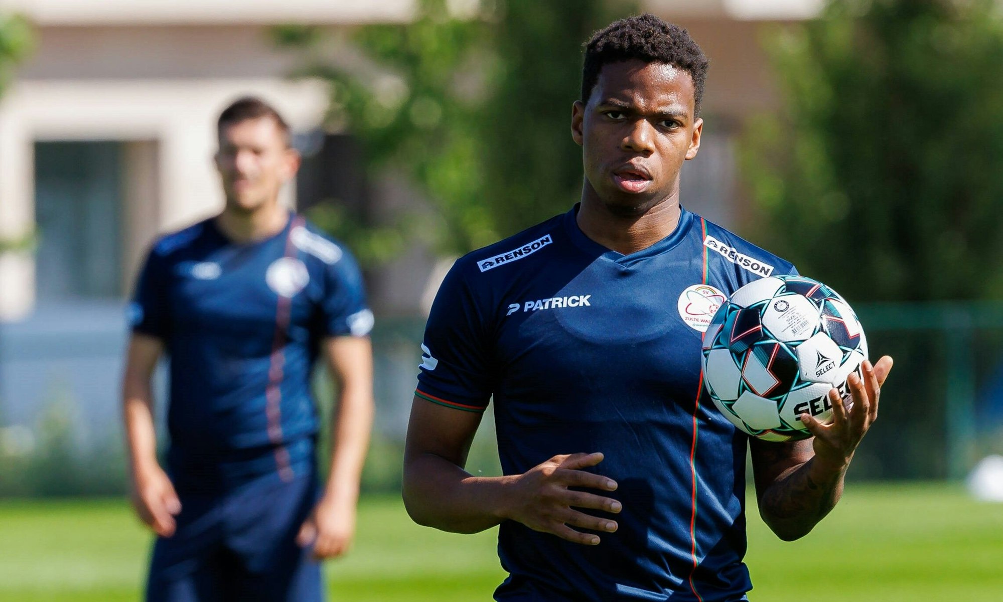 Charly Musonda hält im Training des belgischen Erstligisten SV Zulte Waregem einen Ball in der Hand