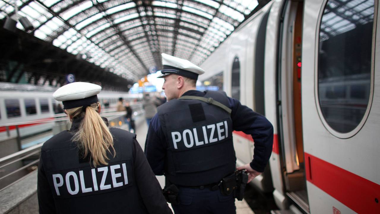Zwei Einsatzkräfte der Bundespolizei gehen einen Bahnsteig im Kölner Hauptbahnhof entlang, neben ihnen steht ein ICE.