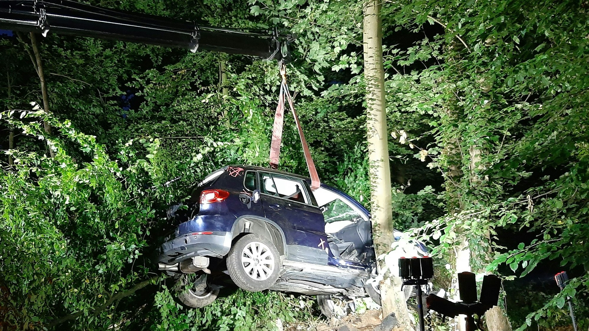 Auto wird von Kran aus dem Wald abgeschleppt.