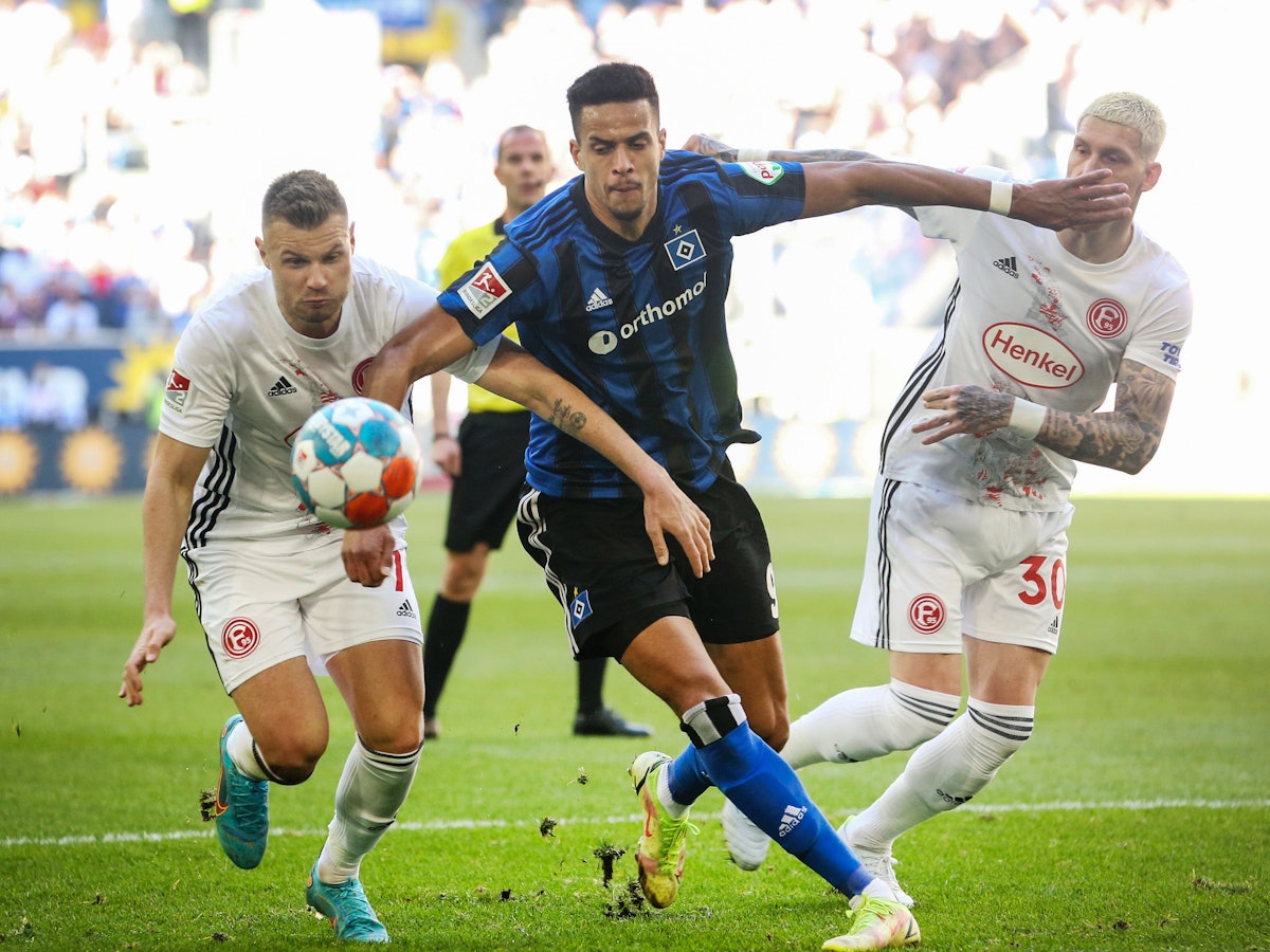 Die Düsseldorfer Florian Hartherz (l) und Jordy de Wijs (r) versuchen den Hamburger Robert Glatzel vom Ball zu trennen.
