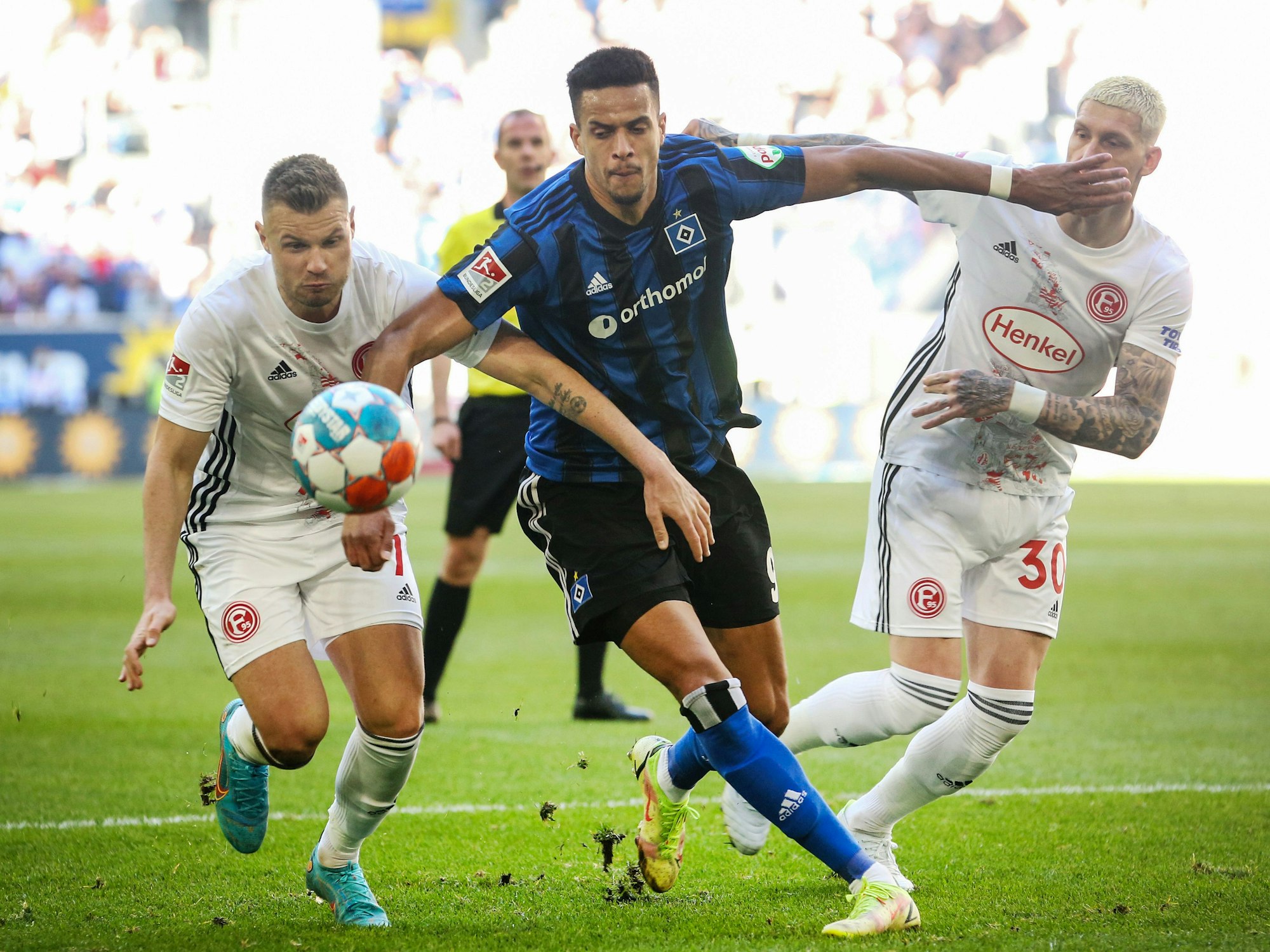 Die Düsseldorfer Florian Hartherz (l) und Jordy de Wijs (r) versuchen den Hamburger Robert Glatzel vom Ball zu trennen.