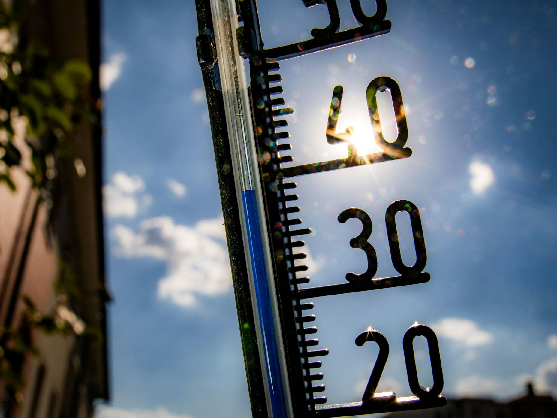 Ein Thermometer an einer Hauswand klettert in Richtung der 40-Grad-Marke.