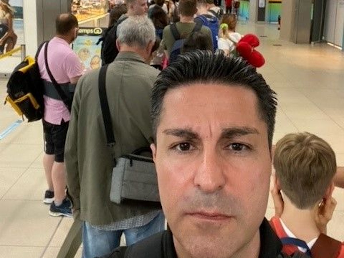 Ein Mann macht ein Selfie in einer Warteschlange.