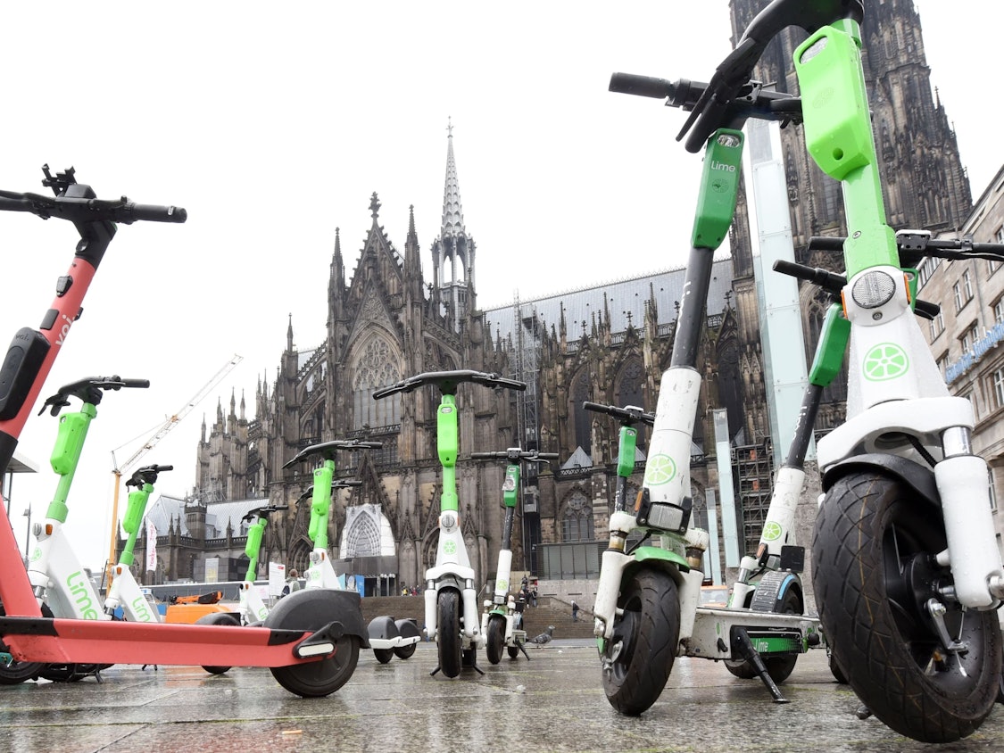 Elektroroller stehen auf dem Bahnhofsvorplatz in Köln.