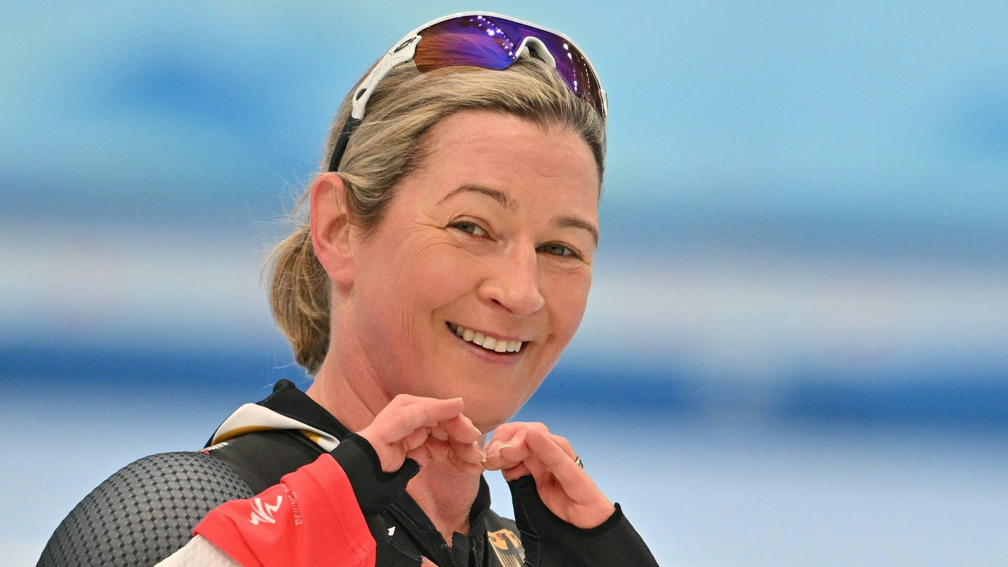 Claudia Pechstein formt ein Herz in die Kamera und lächelt